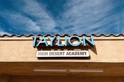 The front of the Taylion building with the sign in the middle and blue sky in the background